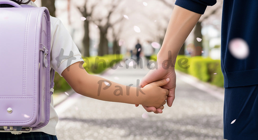 フリー素材 無料 写真|桜の下で手をつなぐ親子の手元、無地ランドセルで匿名性
