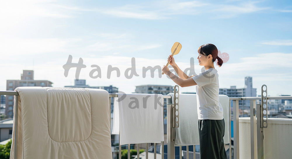 フリー素材 無料 写真|ベランダで布団を干してたたく日本人主婦の布団ケアシーン 背景素材