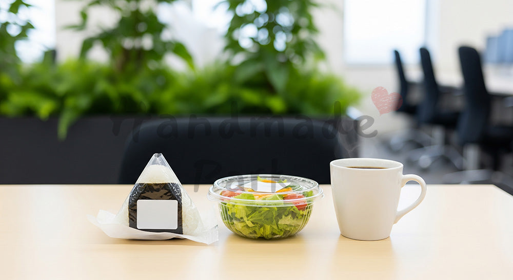 フリー素材 無料 写真|オフィス休憩スペースのテーブルにコンビニ風おにぎりとコーヒーが並ぶ時短ランチイメージ 余白あり