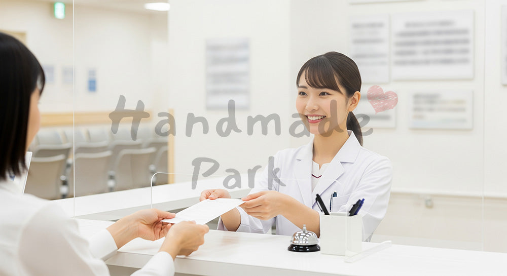 フリー素材 無料 写真|受付カウンターで患者に受付票を手渡す日本人医療事務スタッフ 背景素材
