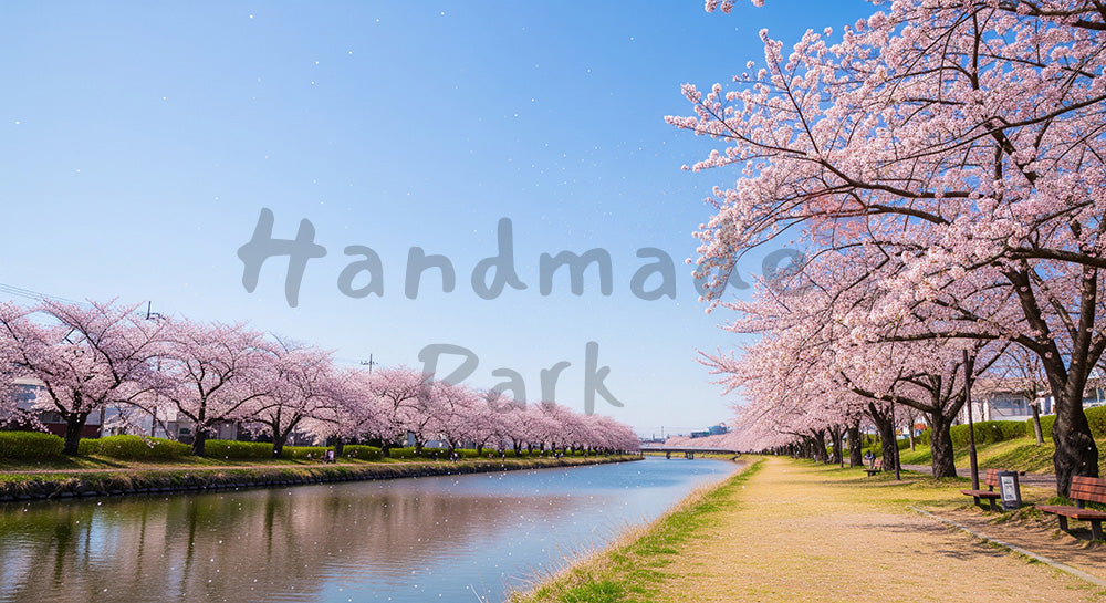 フリー素材 無料 写真|青空と桜吹雪が川沿いに舞う春の横長風景、ロゴや文字のないバナー向け高品質テキストスペースバックグラウンド写真 デザイナー向け