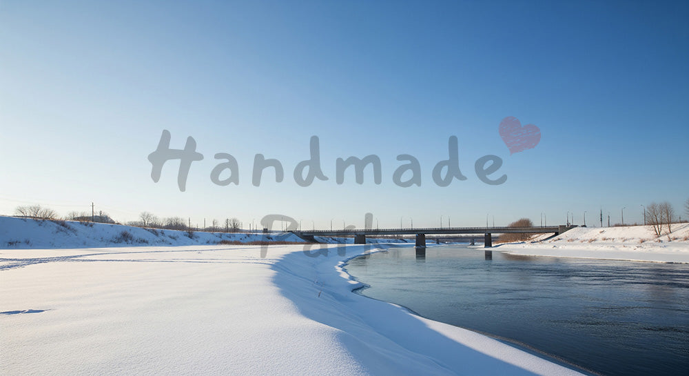 フリー素材 無料 写真|雪の川沿いとシンプルな橋に広がる冬の青空、街づくりやインフラ表現に使える横長バックグラウンド写真 デザイナー向け