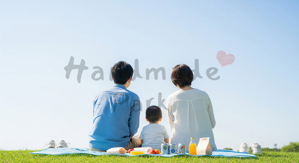 フリー素材 無料 写真|ピクニックで空を眺める日本人家族の後ろ姿、青空が広がる休日の温もり