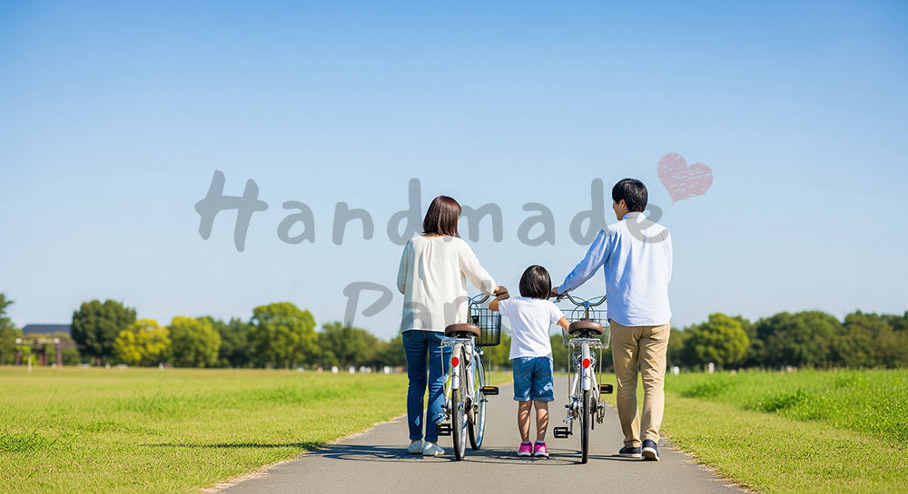 フリー素材 無料 写真|公園で自転車を押す日本人家族の後ろ姿、青空と一緒に描くアクティブな休日