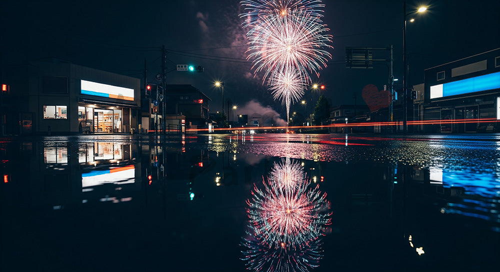 フリー素材 無料 写真|日本の街角を想起する余白広めのドラマチック夜景広告背景、花火と濡れた路面反射が活きる