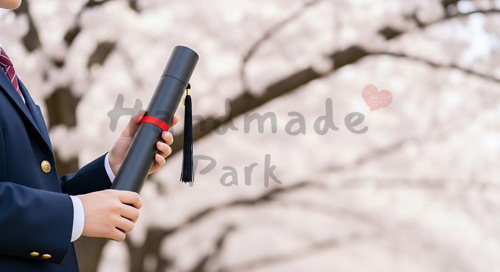 フリー素材 無料 写真|卒業証書筒を持つ日本人の手元 桜ボケ余白|文字入れしやすい余白あり