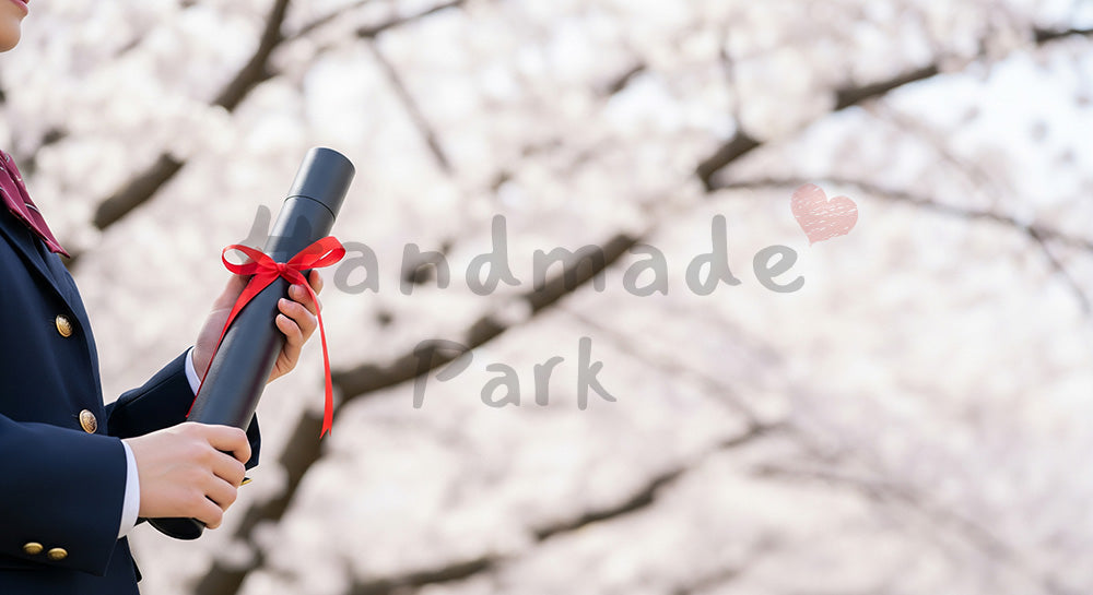 フリー素材 無料 写真|卒業証書筒を持つ日本人の手元 桜ボケ余白|余白たっぷりで見出しが入れやすい
