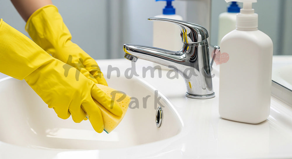 フリー素材 無料 写真｜白い洗面ボウルをスポンジで磨く日本人主婦の手元、無地ボトルで衛生的な洗面台掃除