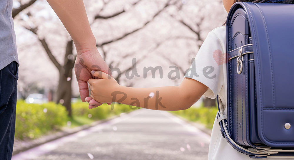 フリー素材 無料 写真｜無地ランドセルで匿名性、桜の下で手をつなぐ親子の手元