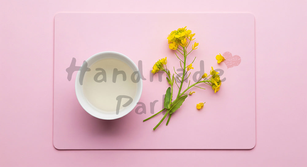 フリー素材 無料 写真｜白酒の無地盃と菜の花を置いたミニマルフラットレイ、桃色背景