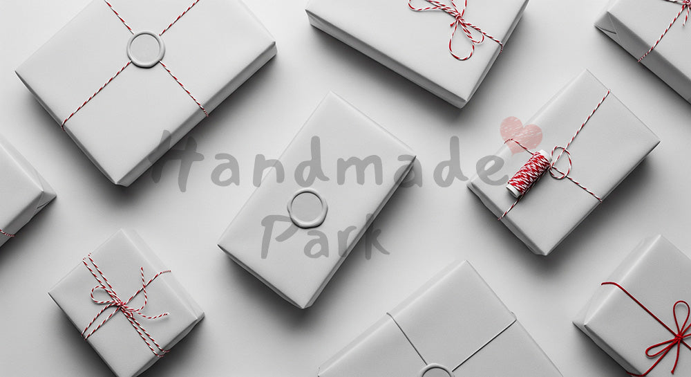 フリー素材 無料 写真｜白とベージュの無地包装ギフトのフラットレイ、赤い糸アクセント