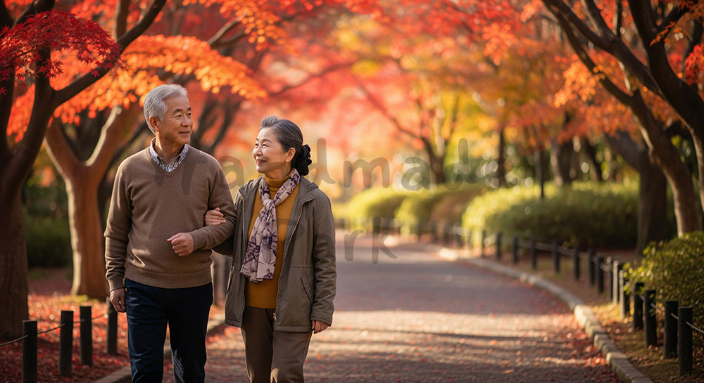 フリー素材 無料 写真｜紅葉の公園を歩く日本人シニア夫婦、健康的ライフスタイルと安心感を伝える秋の散歩道シーン 写真背景