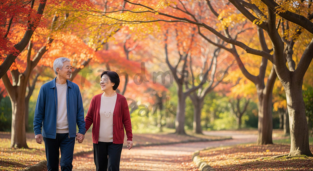 フリー素材 無料 写真｜紅葉の公園を歩く日本人シニア夫婦健康的ライフスタイルと安心感を伝える秋の散歩道シーン