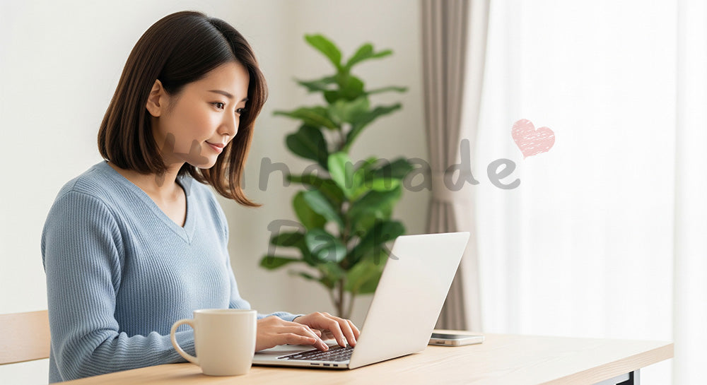 フリー素材 無料 写真｜汎用の在宅ワークバックグラウンドとして使いやすい穏やかな室内シーン、自然光の木目デスクでノートPCに向かう20代日本人女性