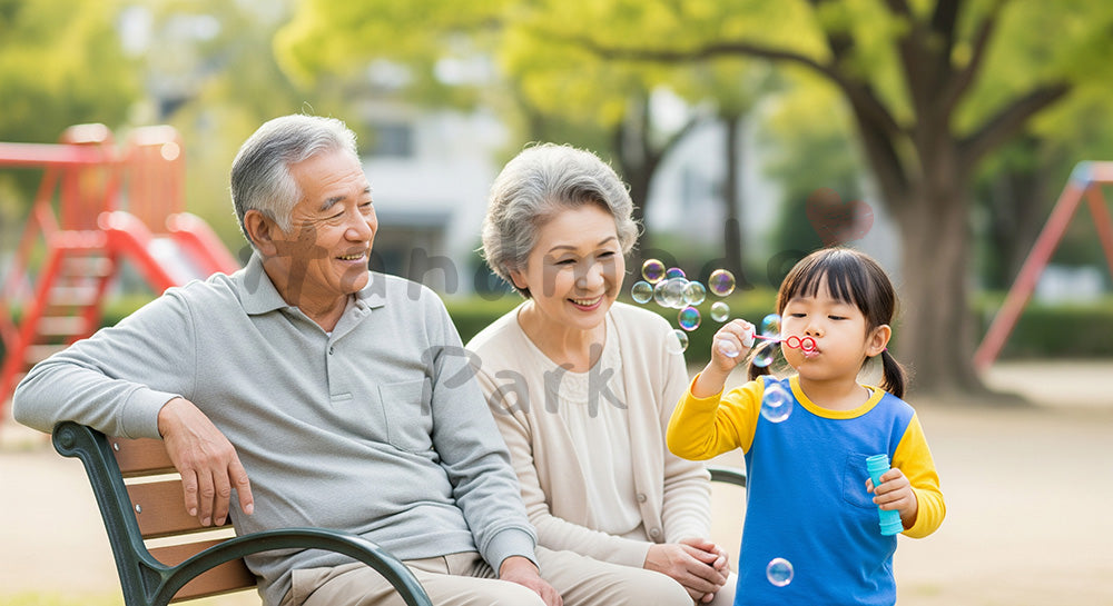 フリー素材 無料 写真｜公園のベンチで孫とシャボン玉遊びを楽しむ日本人祖父母の子育てサポート（表現6）