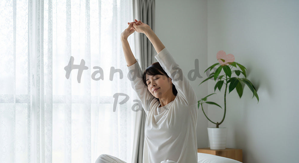 フリー素材 無料 写真｜朝の寝室でストレッチをする日本人女性のセルフケア（表現1）