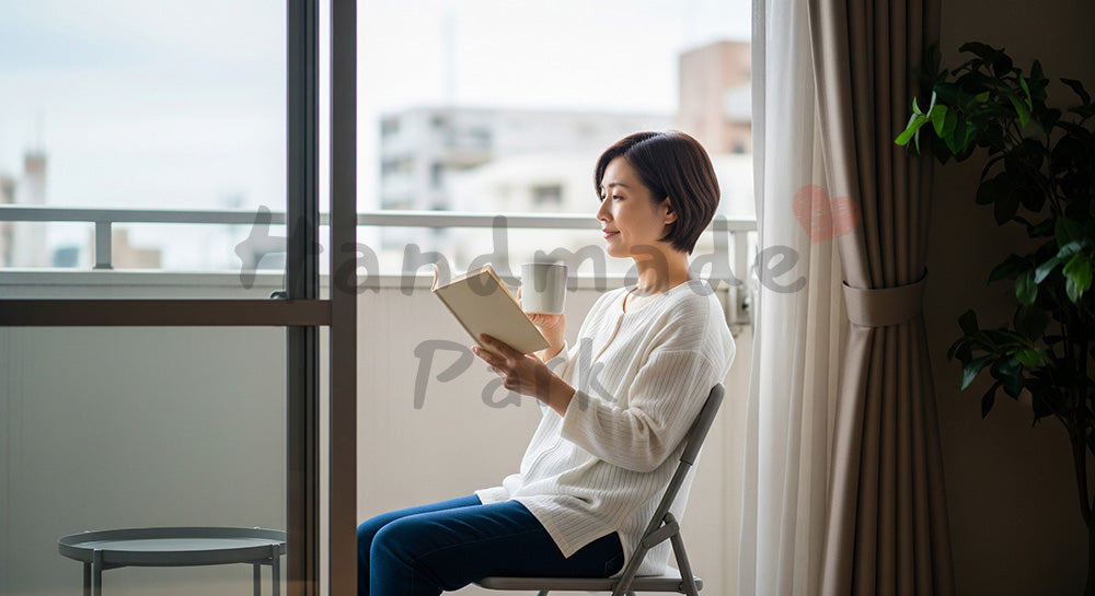 フリー素材 無料 写真｜ベランダで本とマグカップを手に外気浴を楽しむ日本人主婦の休日シーン コピースペースあり