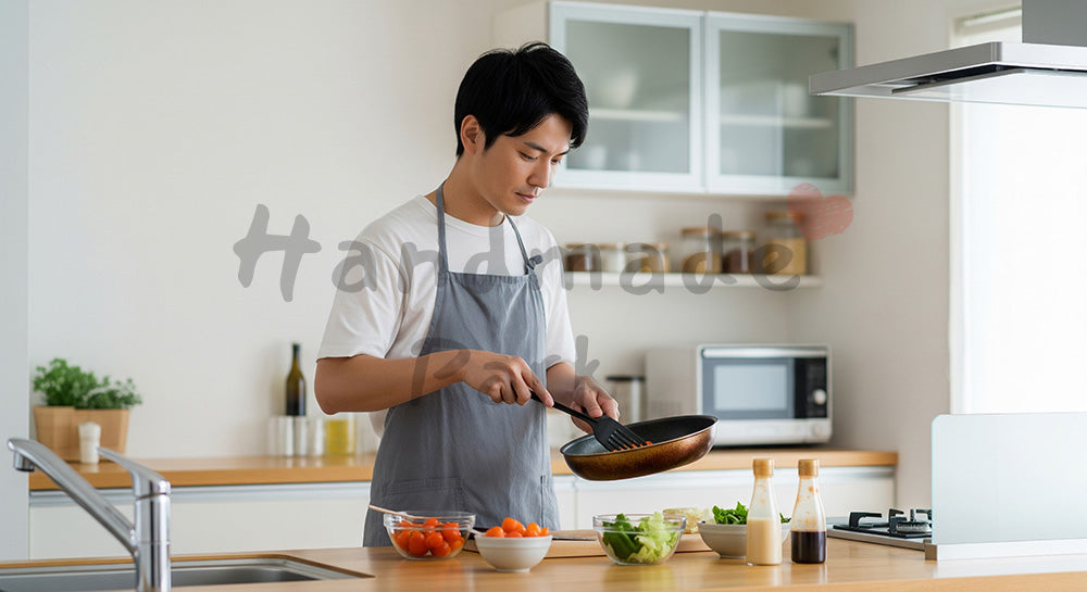 フリー素材 無料 写真｜エプロン姿の日本人夫が夕食づくりをする共働き家庭のキッチンシーン コピースペースあり