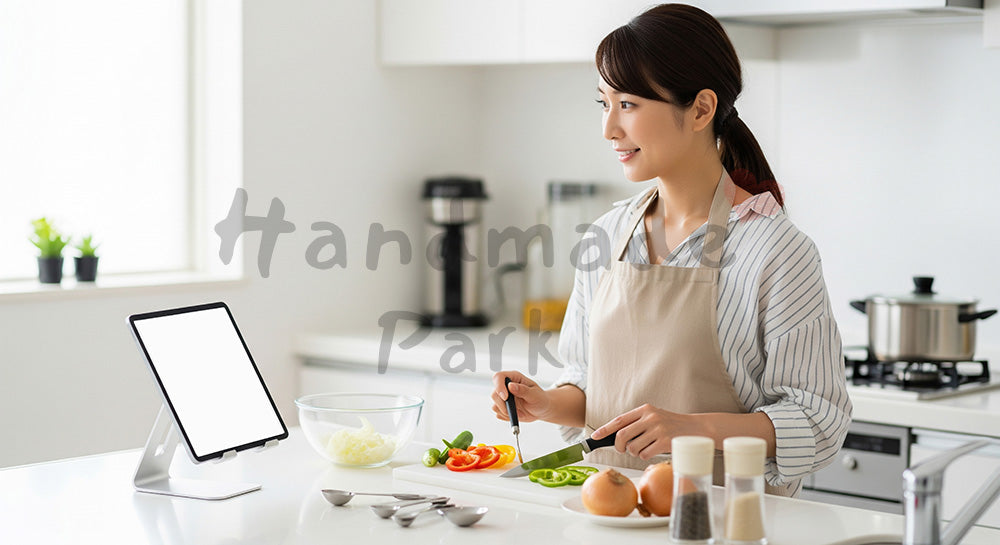 フリー素材 無料 写真｜タブレットでオンライン料理教室を受けながら自宅キッチンで調理する日本人女性（表現5）
