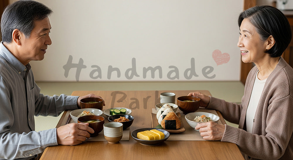 フリー素材 無料 写真｜おにぎりや味噌汁を並べた和食ランチを夫婦で囲む日本人シニア夫婦の食卓シーン（表現3）