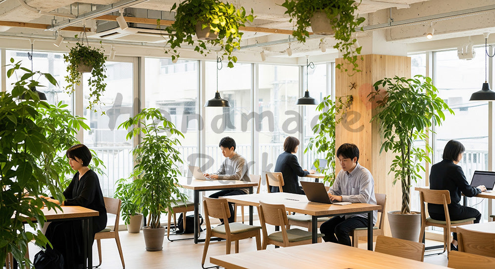 フリー素材 無料 写真｜観葉植物に囲まれたコワーキングスペースで働く日本人リモートワーカー 背景素材