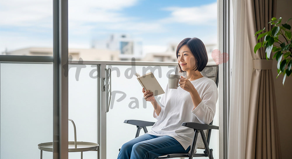 フリー素材 無料 写真｜ベランダで本とマグカップを手に外気浴を楽しむ日本人主婦の休日シーン 写真背景