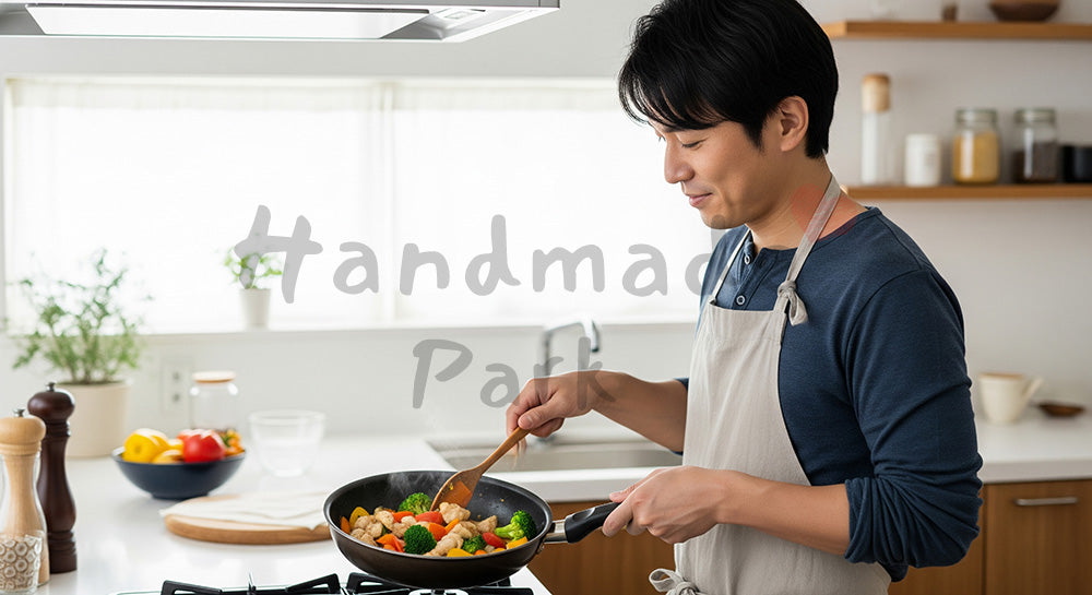 フリー素材 無料 写真｜エプロン姿の日本人夫が夕食づくりをする共働き家庭のキッチンシーン 余白あり