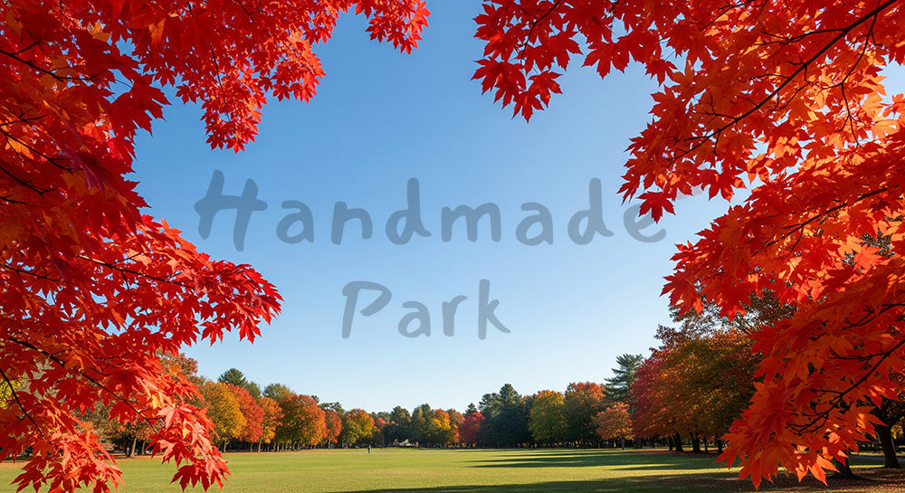 フリー素材 無料 写真｜紅葉の葉の間から青空と公園が見える秋のフレーム構図、見出し配置に強い横長背景写真 デザイナー向け