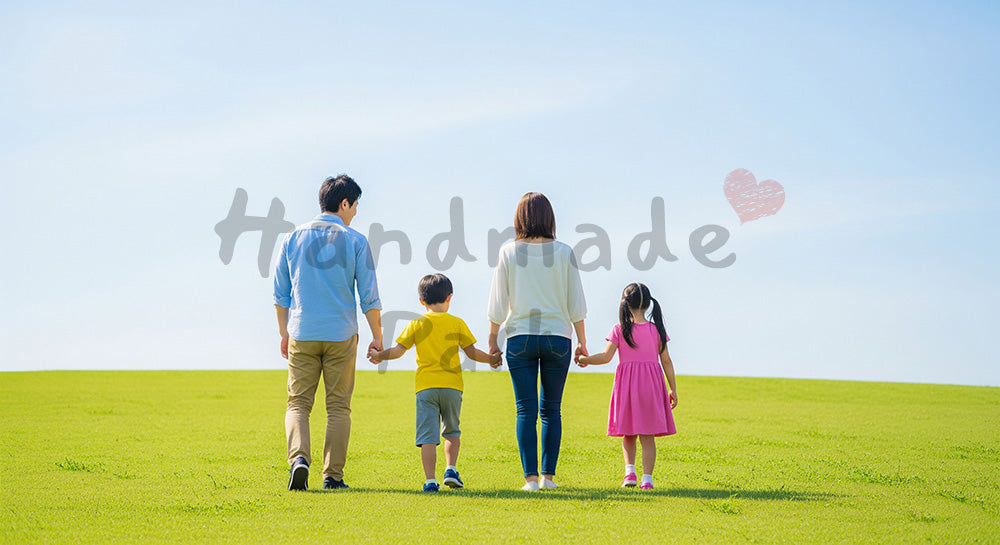 フリー素材 無料 写真｜青空の丘を歩く日本人家族の後ろ姿、手をつなぐ温かな休日シーン