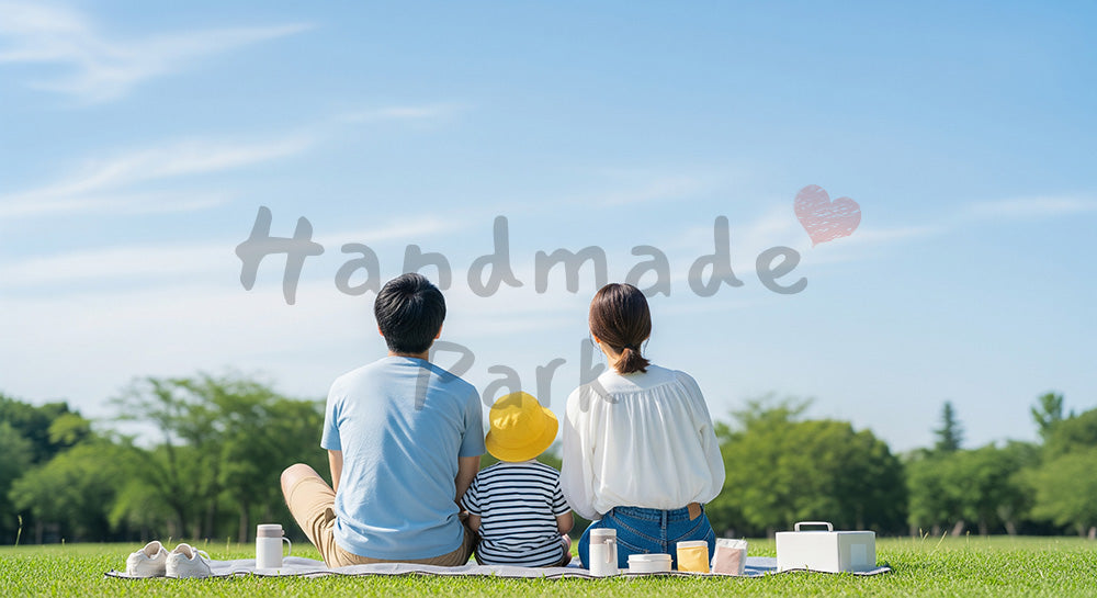 フリー素材 無料 写真｜ピクニックで空を眺める日本人家族の後ろ姿、青い空が広がる休日の温もり