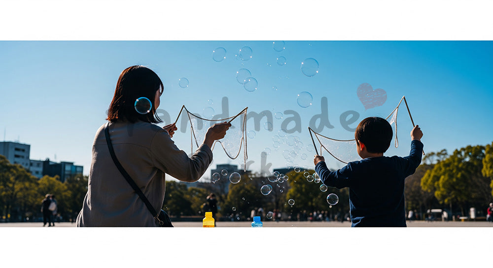 フリー素材 無料 写真｜青空にシャボン玉を飛ばす日本人親子の後ろ姿、やさしい公園の休日