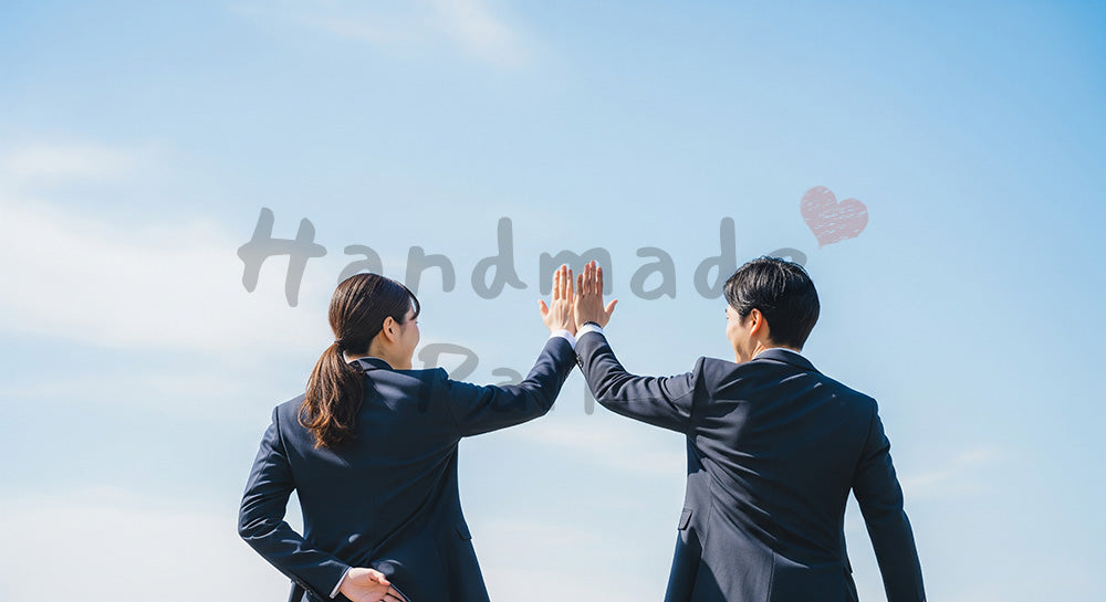 フリー素材 無料 写真｜青空の下でハイタッチする日本人同僚の後ろ姿前向きなチームワーク
