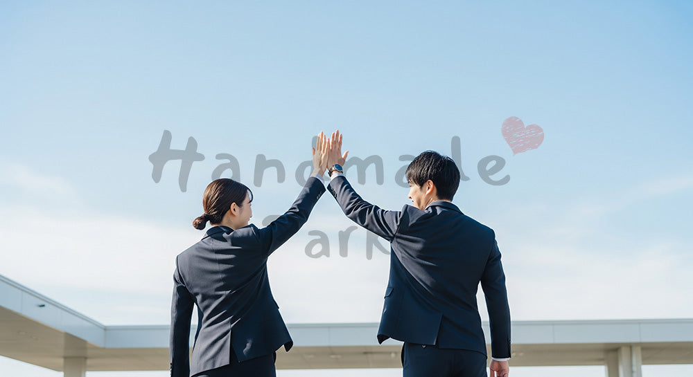 フリー素材 無料 写真｜前向きなチームワークのある青空の下でハイタッチする日本人同僚の後ろ姿