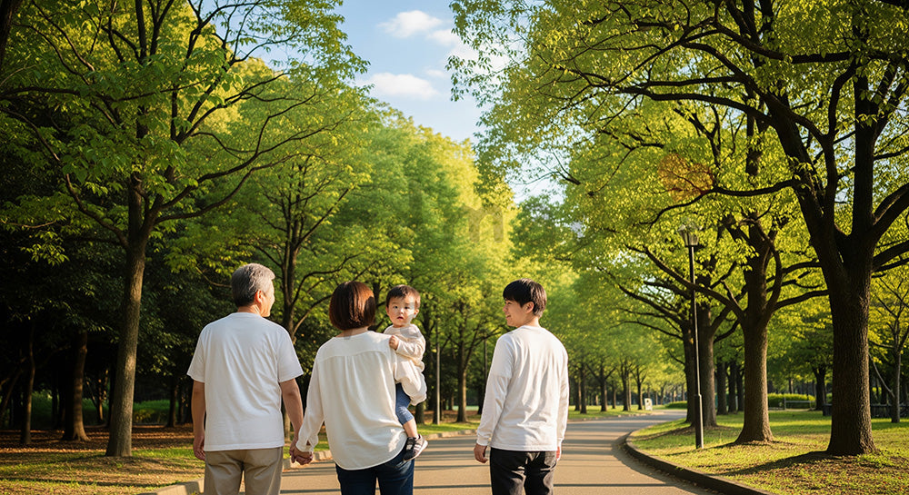 フリー素材 無料 写真｜青い空の公園を歩く日本人3世代家族の後ろ姿、世代をつなぐ温かな散歩