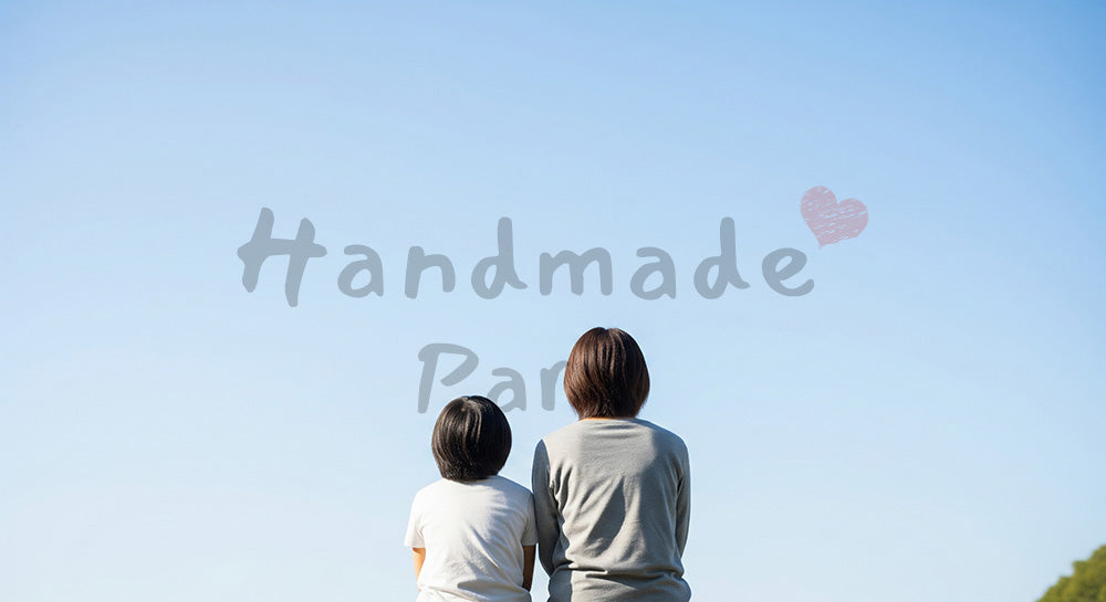 フリー素材 無料 写真｜肩を並べて空を眺める日本人親子の後ろ姿、青空と安心感のある公園時間