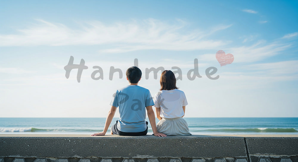 フリー素材 無料 写真｜堤防に座って海と青空を眺める日本人カップルの後ろ姿、静かな幸福感
