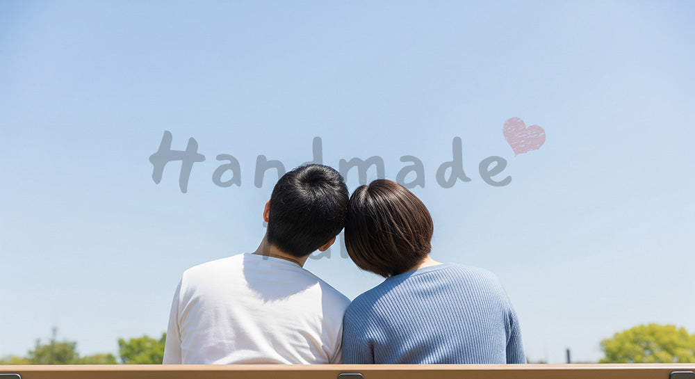 フリー素材 無料 写真｜青空と穏やかな恋人の時間のあるベンチで肩を寄せる日本人カップルの後ろ姿