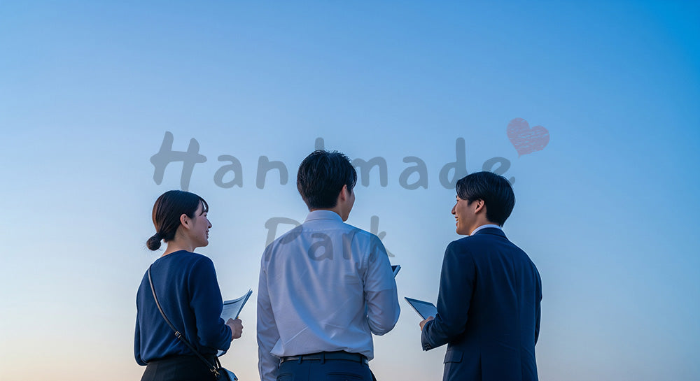 フリー素材 無料 写真｜夕方前の青い空の下で話し合う日本人同僚の後ろ姿、前向きな相談とチーム感
