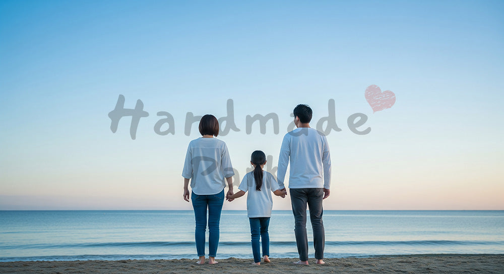 フリー素材 無料 写真｜夕方前の海辺を歩く日本人家族の後ろ姿、青空と穏やかな家族時間のスペース
