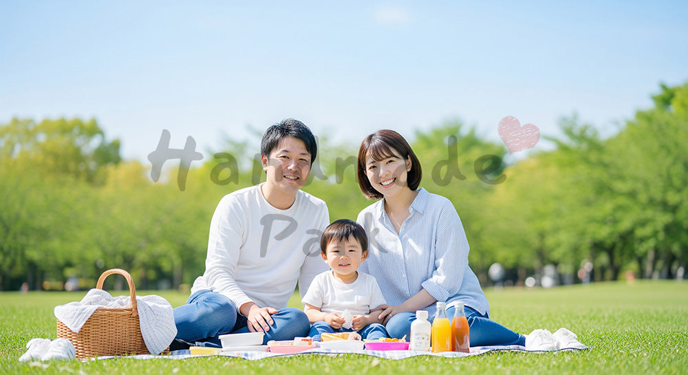 フリー素材 無料 写真｜芝生でピクニックする日本人家族（正面） 余白あり