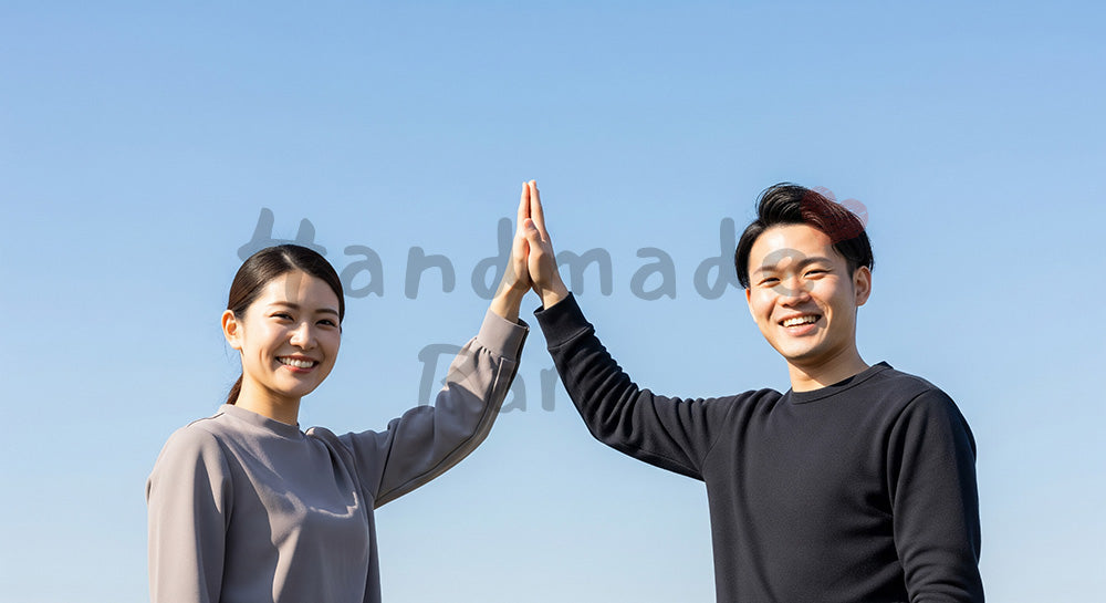 フリー素材 無料 写真｜青空の下でハイタッチする日本人同僚（正面） 背景素材