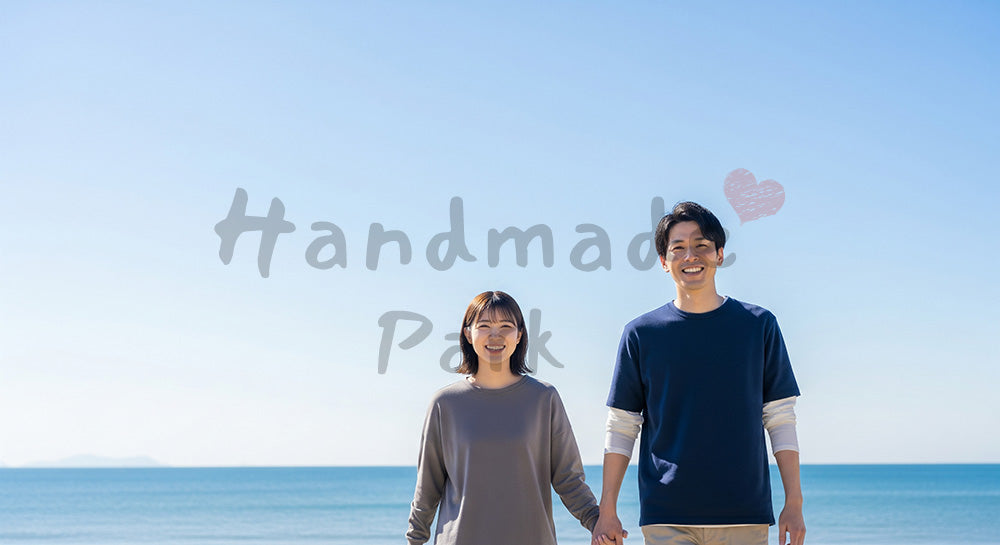 フリー素材 無料 写真｜青空と海辺で微笑む日本人カップル（正面） 写真バックグラウンド 背景素材