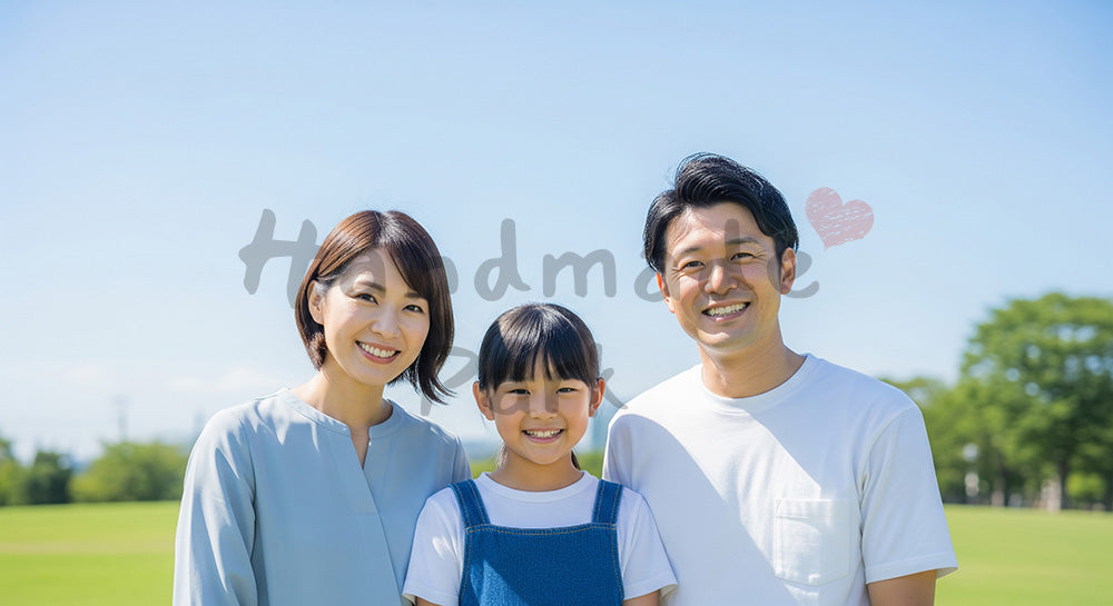 フリー素材 無料 写真｜青空と芝生で笑う日本人家族（正面・集合）