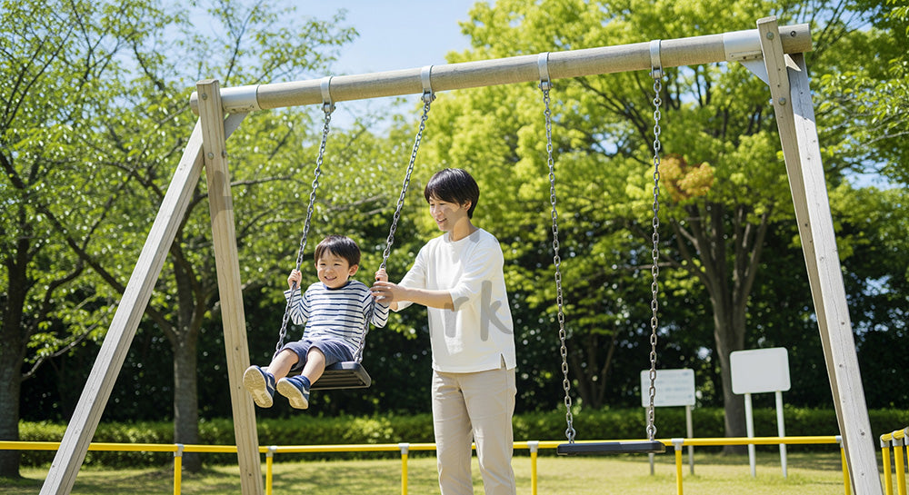 フリー素材 無料 写真｜明るい公園のブランコで遊ぶ日本人親子、子育ての温かさが伝わる写真