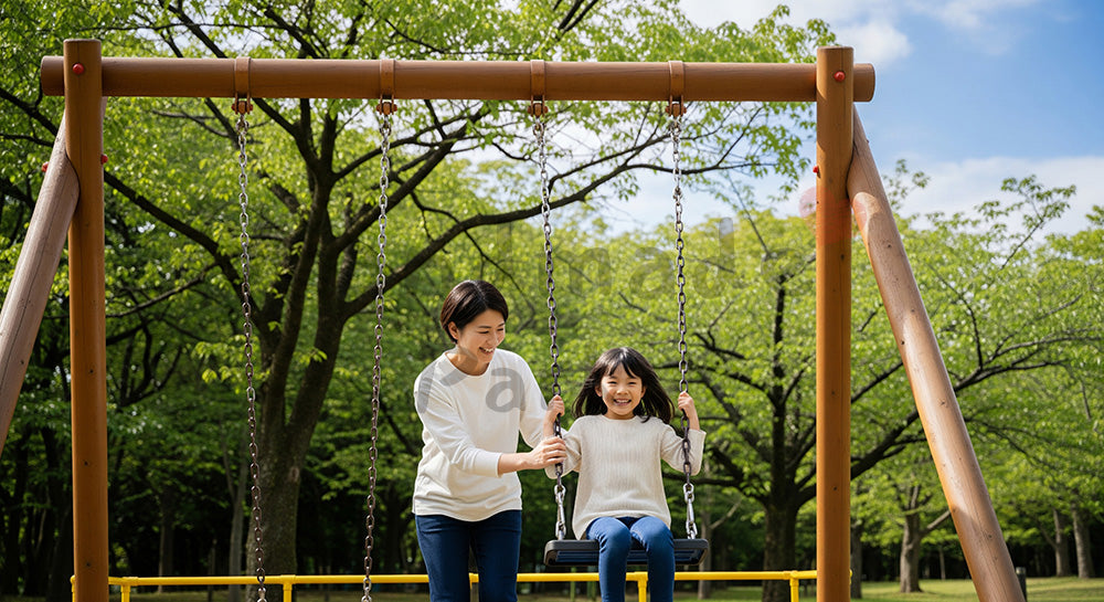フリー素材 無料 写真｜日差しのある公園のブランコで遊ぶ日本人親子、子育ての温かさが伝わる写真
