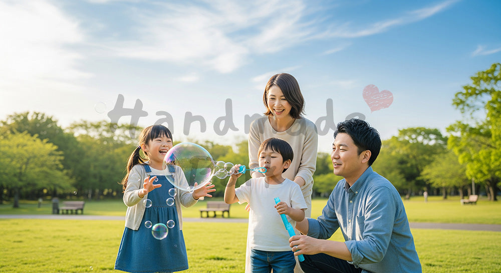 フリー素材 無料 写真｜晴れた公園の芝生でシャボン玉を楽しむ日本人家族、透明感のある休日写真