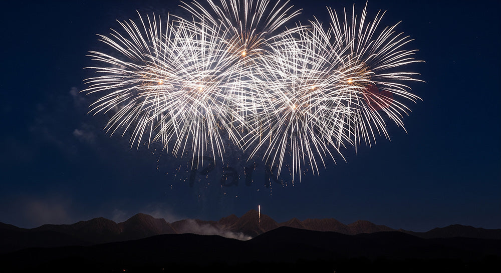 フリー素材 無料 写真｜花火と山の稜線 夜空の余白が大きいドラマチックな夏の背景素材