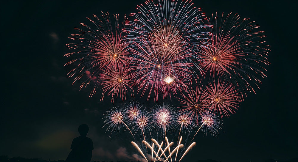 フリー素材 無料 写真｜花火を見上げる日本人の一人シルエット 余白が広いドラマチックな夜空背景