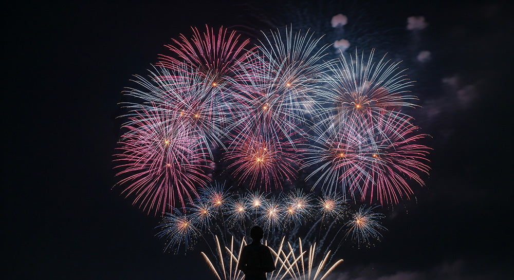 フリー素材 無料 写真｜花火を見上げる日本人の一人シルエット 余白が広い情緒的な夜空背景