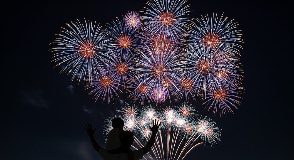 フリー素材 無料 写真｜夜空の余白が大きい温かい夏の背景、花火と肩車の日本人親子シルエットが活きる